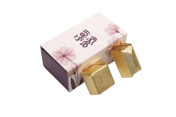 Decorative box with floral design and two gold-wrapped chocolates.