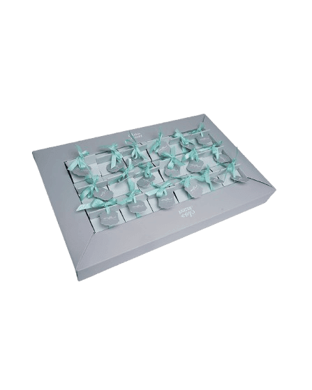 Elegant white gift box with multiple small compartments, each filled with a light blue ribbon bow.