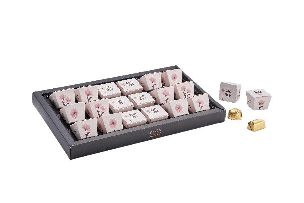 Box of assorted chocolates in decorative paper wrappers with floral design.